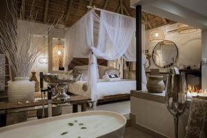 侯斯普瑞特African Flair Boutique Safari Lodge的带浴缸的浴室和1间带1张床的卧室