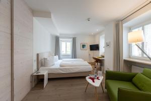 拜尔恩格里斯弗彻斯巴拉酒店的一间卧室配有一张床和一张绿色沙发