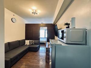 马尼拉Heart of Makati, Fully furnished condo, cbd central location的带沙发和电视的客厅