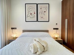 卡萨布兰卡Dynasty Estate - Maarif residency的一张白色的床,墙上有三张照片