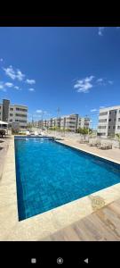 费拉迪圣安娜Apartamento Aconchego condomínio florida的大楼前的大型蓝色游泳池