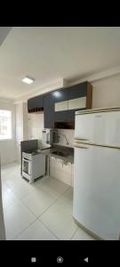 费拉迪圣安娜Apartamento Aconchego condomínio florida的白色的厨房配有白色冰箱