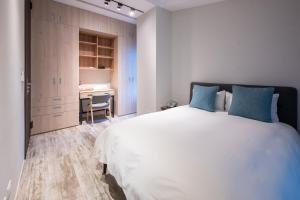 三义向草语虫的卧室配有带蓝色枕头的大型白色床