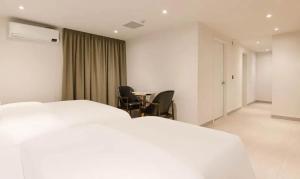 仁川市Hotel Lounge 7的酒店客房带一张床、一张桌子和椅子
