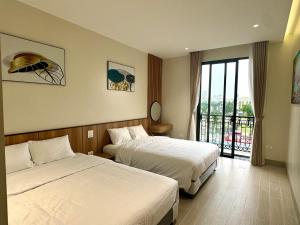 岑山MARIS HOTEL SẦM SƠN的酒店客房设有两张床和一个阳台。