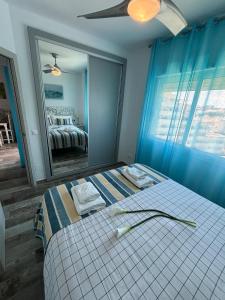 贝纳尔马德纳Benal Beach 907的一间卧室配有一张带蓝色墙壁和镜子的床