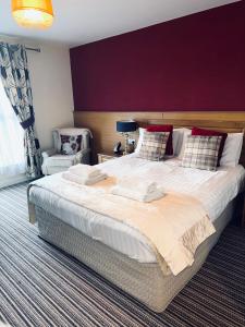 StranocumThe Hedges Hotel的一间卧室配有一张大床和紫色墙壁