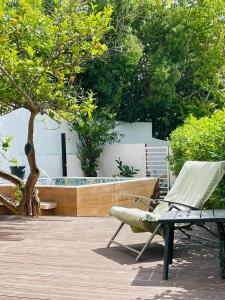 奥埃拉斯Casa do Mar - Golf Jamor的一个带椅子和浴缸的庭院
