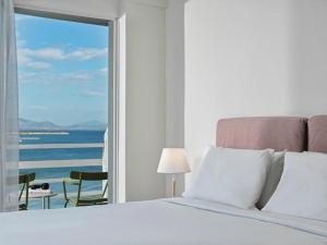 马蒂NLH Mati Seafront - Neighborhood Lifestyle Hotels的一间卧室配有一张床,享有海景