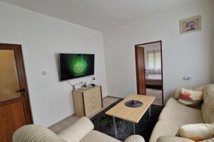 大特尔诺沃ViPo Vista Veliko Tarnovo的客厅配有沙发和墙上的电视