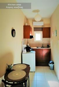 拉米亚Efi Studio 1 Lamia的一间带桌子和白色冰箱的小厨房