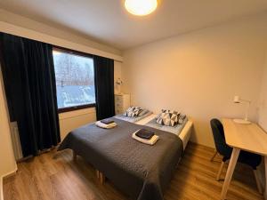 伊瓦洛Pine Sky Apartments的一间卧室配有一张床、一张书桌和一个窗户。