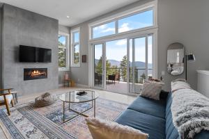 基洛纳Luxury Home with Amazing Lake Okanagan Views的客厅设有蓝色的沙发和壁炉