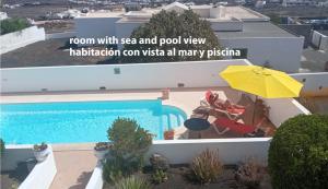 蒂亚斯Elvira的一座带游泳池和黄色遮阳伞的房子