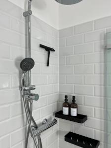 瓦尔堡SecretApartment: Fewo in Warburg的浴室设有淋浴,架子上装有两瓶水