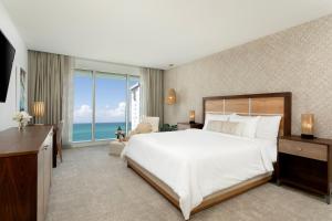 圣胡安Casa Costera, Isla Verde Beach, Apartments by Marriott Bonvoy的一间卧室设有一张大床和一个大窗户
