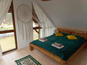 Borowy MłynRozmaryn - Komfortowy domek całoroczny na Kaszubach的一间卧室配有一张带绿色床单和黄色枕头的床。