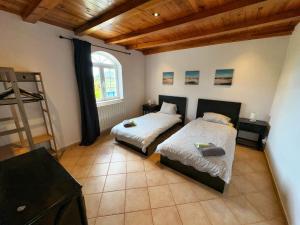 拉戈阿Oasis Camp Portugal的一间卧室设有两张床和木制天花板
