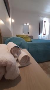 锡尼亚Home Signa Via Roma 26的一间卧室配有两张床和一张桌子上的毛巾