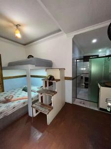 大普拉亚Suíte Garden的一间卧室设有一张床和一个玻璃淋浴间