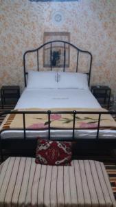 艾济拉勒Familly House的卧室内的一张床位,旁边设有长凳