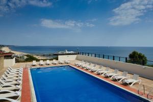 伯恩茅斯万豪伯恩茅斯高崖酒店的一个带躺椅的游泳池和海洋