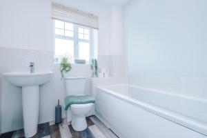 俄乌洛Modern Semi detached in a quiet location, Driveway parking的白色的浴室设有水槽、浴缸和卫生间。