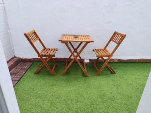 卡拉塔尤德apartamento con jacuzzi, El Rincón de Ayud的两把木椅和一张桌子放在草地上