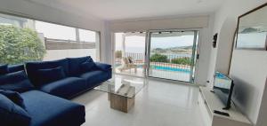 桑特费柳德吉克索尔斯COSTA BRAVA SUITES VILLA Cala Jonca的一间带蓝色沙发的客厅和一个阳台