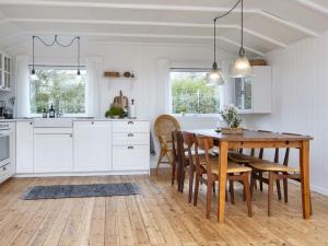 斯楚厄Holiday home Struer XI的白色的厨房配有木桌和椅子