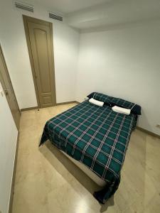 马德里Hotelly Atocha的一间卧室配有一张带铺着平底毯的床