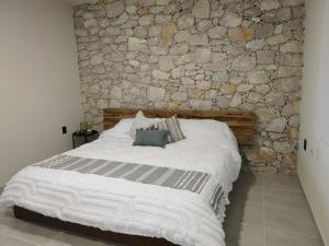 特科早特拉Casa Xahá的石墙房间内的一张床位