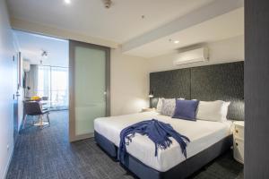 墨尔本Corporate Living Accommodation Abbotsford的酒店客房设有一张大床和一张书桌。