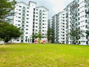 斯里曼绒HomeSTAY PANGSAPURI SAMUDERA SERI MANJUNG LUMUT的一座公园,里面设有高高的公寓楼和游乐场