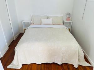 纳皮尔Sunny Modern Cottage - Close to Airport的一间卧室配有一张带白色床罩的床