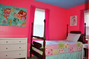 HintonRiverfront Property in NRG National Park near Sandstone Falls- Wi-Fi, Pet-Friendly的卧室设有粉红色的墙壁、一张床和一个梳妆台