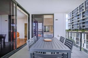 布里斯班Regatta Hideaway - A Breezy Balcony Residence的一间配备有蓝色桌子和椅子的用餐室