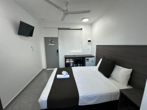 达尔文Darwin Resort的一间卧室配有一张带白色毛巾的床