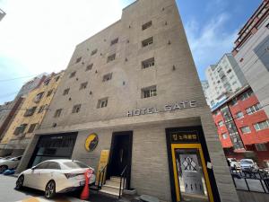 仁川市Hotel Gate的一座酒店大楼,前面有停车位