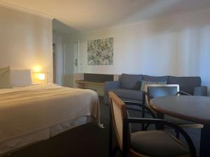 德纳姆鲨鱼湾海瑞泰度假酒店的酒店客房配有床、沙发和桌子。