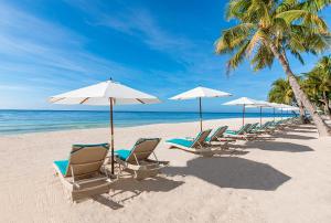 邦劳Henann Premier Coast Resort的海滩上的一排椅子和遮阳伞