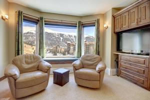 铜山TL411 Telemark Lodge studio的客厅配有两把椅子和大窗户