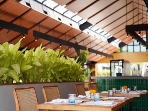 塞米亚克Cross Paasha Bali Seminyak的用餐室配有桌椅和植物