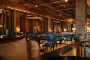 南迪Crowne Plaza Fiji Nadi Bay Resort & Spa, an IHG Hotel的一间带桌椅和蓝色椅子的餐厅