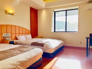 御殿场市Hotel Square FujiGotemba的酒店客房设有两张床和窗户。