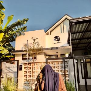 岩望seVilla Guest House Pasuruan的站在房子前面的人