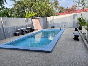 巴东马士力OYO 90967 Homestay Chalet Warisan Siti的一个带桌椅的小型游泳池
