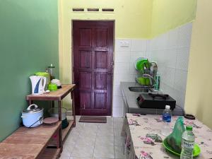 巴东马士力OYO 90967 Homestay Chalet Warisan Siti的厨房设有棕色的门和水槽