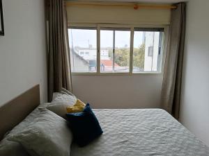 蒙得维的亚Apartamento para cuatro personas totalmente equipado的一间卧室配有一张带窗户的床