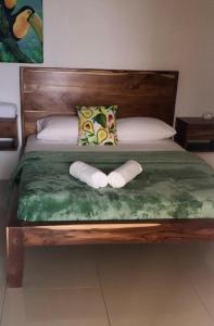 大玉米岛Emerald Luxe Suites的一张带两个枕头的床和两条毛巾